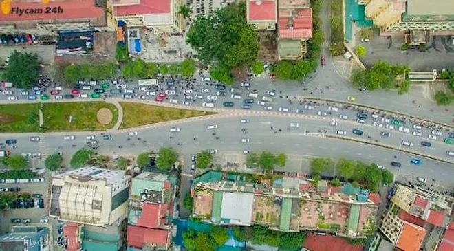 Ngã tư đường lớn ở Hà Nội đông ô tô và xe máy, hai bên là nhà phố, chụp thẳng từ trên xuống
