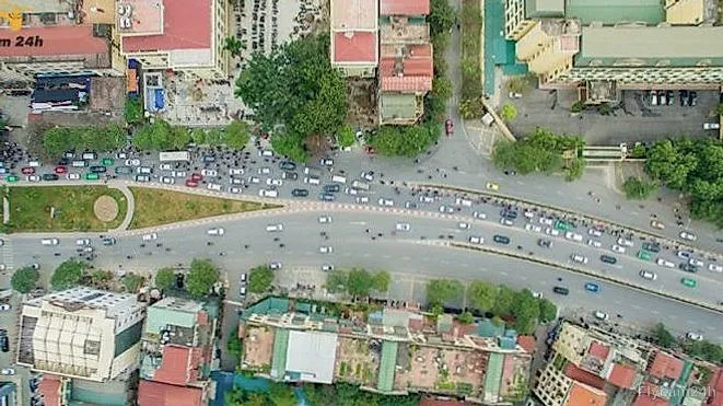 Ngã tư đường lớn ở Hà Nội đông ô tô và xe máy, hai bên là nhà phố, chụp thẳng từ trên xuống