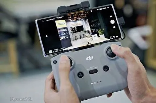 Tay cầm tay điều khiển flycam kẹp điện thoại đang hiển thị hình ảnh trực tiếp từ camera