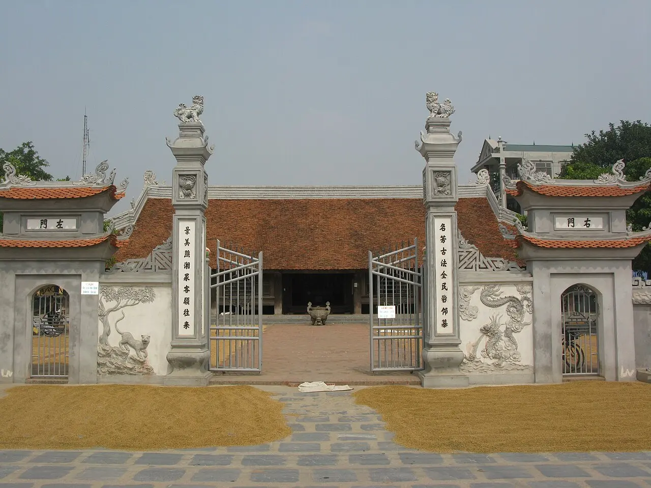 Cổng đình làng có hai trụ biểu và sân gạch phía trước
