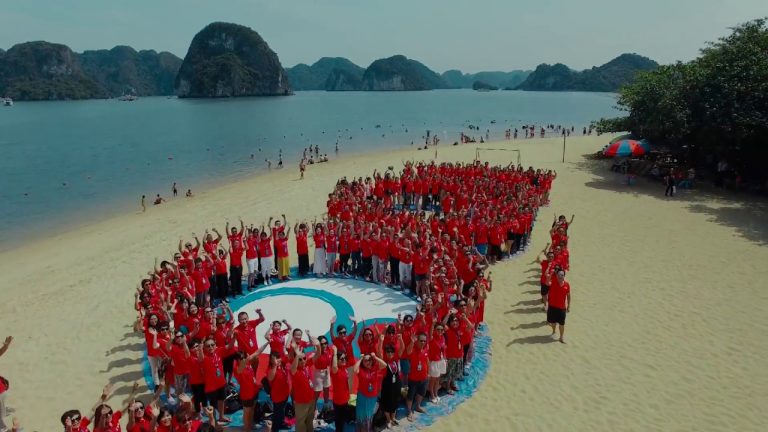Đoàn teambuilding áo đỏ xếp hình trên bãi biển, chụp từ flycam